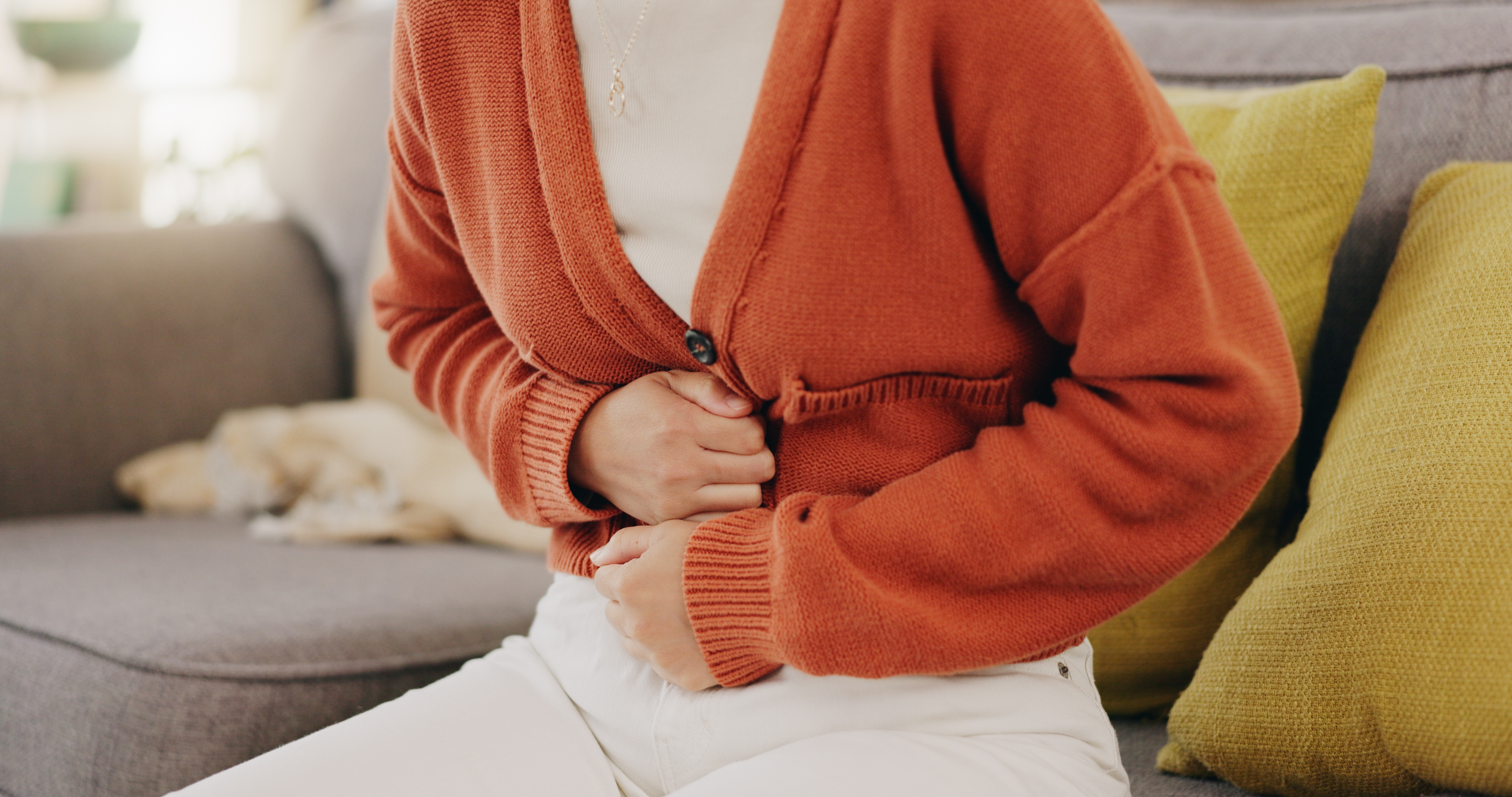 A woman experiencing stomach pain - learn how you can find relief with Vida-Flo's IV hydration treatment for gastrointestinal diseases in Wilmington, NC.