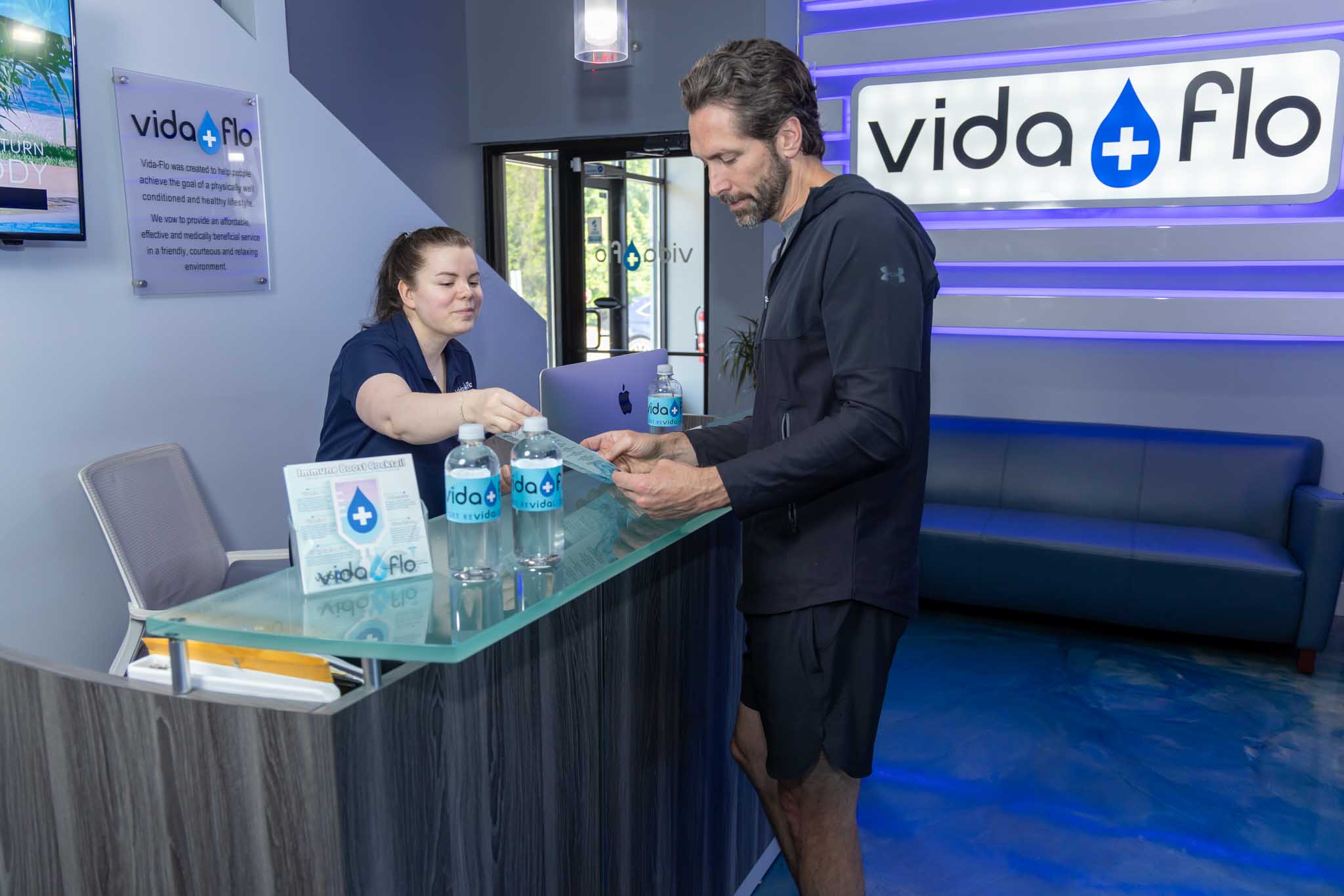 A client going over information with a wellness consultant at Vida-Flo - we offer premier IV hydration treatment for aging in Decatur, GA.