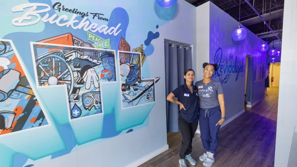 Vida-Flo Buckhead team beside the Buckhead mural
