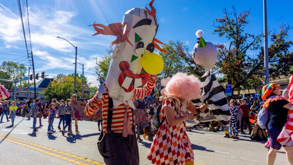 Costumed marchers with giant papier-mache heads in the Little Five Points Halloween parade