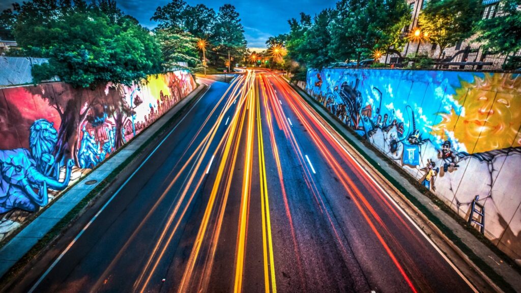 Light trails running through the mural-lined underpass in Chamblee at dusk