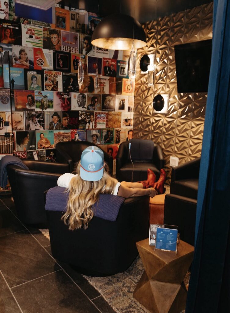 Guest relaxing in the Vida-Flo 5th + Broadway lounge with its record-cover wall