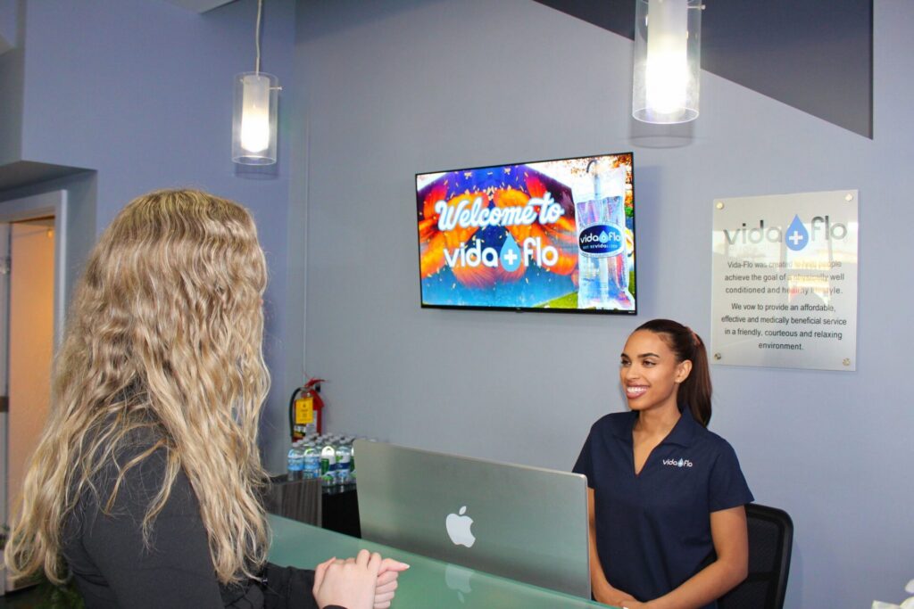 Vida-Flo team member welcoming a guest at the front desk