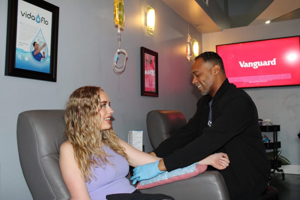 Vida-Flo team member with a guest receiving an IV treatment in a recliner