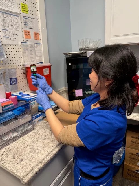 A Vida-Flo Johns Creek nurse in scrubs and gloves preparing a treatment