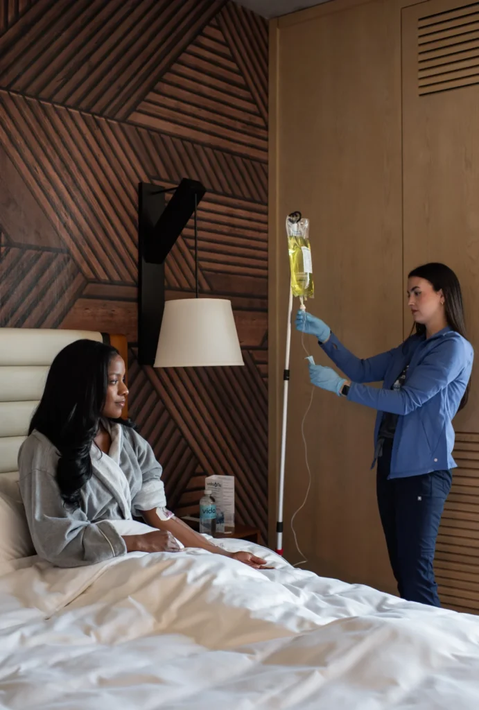 Vida-Flo nurse starting an IV for a guest relaxing in a robe
